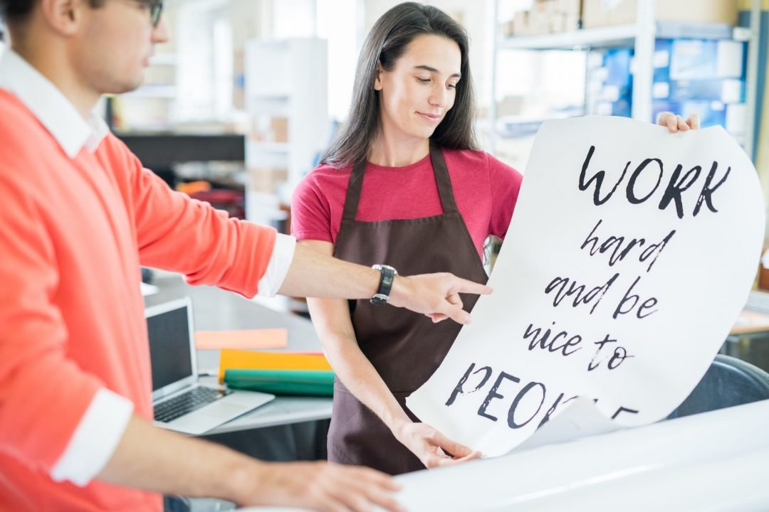 coworking colleagues with printed poster